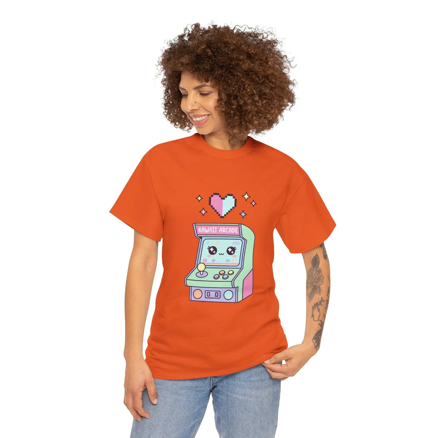 Person wearing an orange t-shirt with a pixel art arcade machine design on a white background